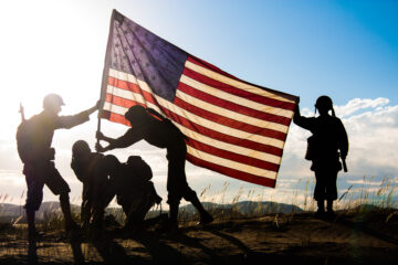 Soldiers in WWII uniforms recreating the raising of the flag on Iwo Jima
