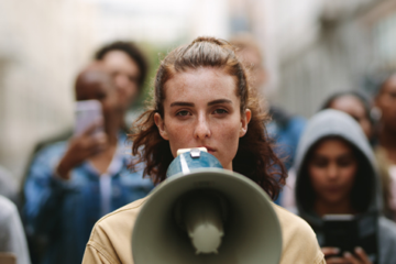 Person speaking into a megaphone during a public demonstration.