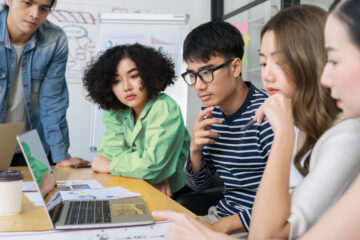 Group of people looking at a lap top screen.