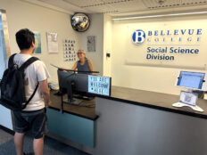 A male student is being helped by a Social Science front desk staff.