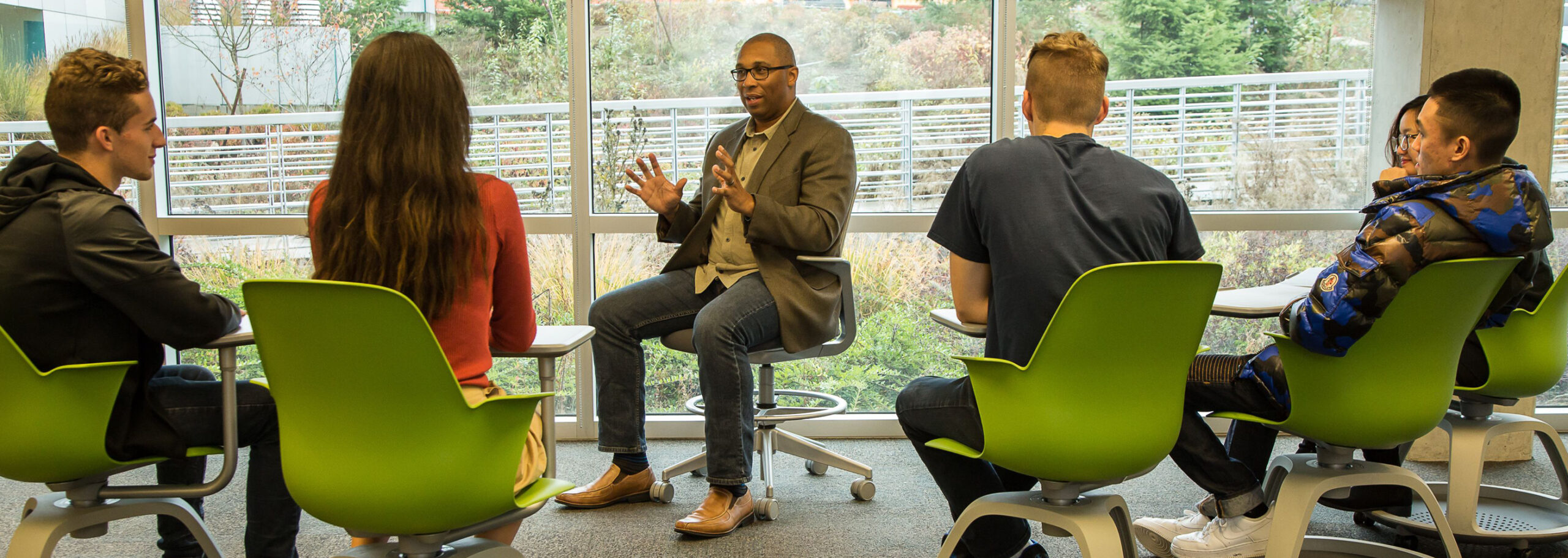 Instructor leads a small group discussion in a classroom.