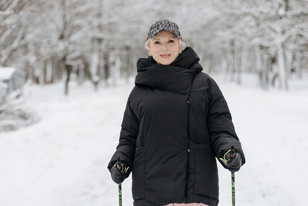 A skier pauses in the snowy woods.