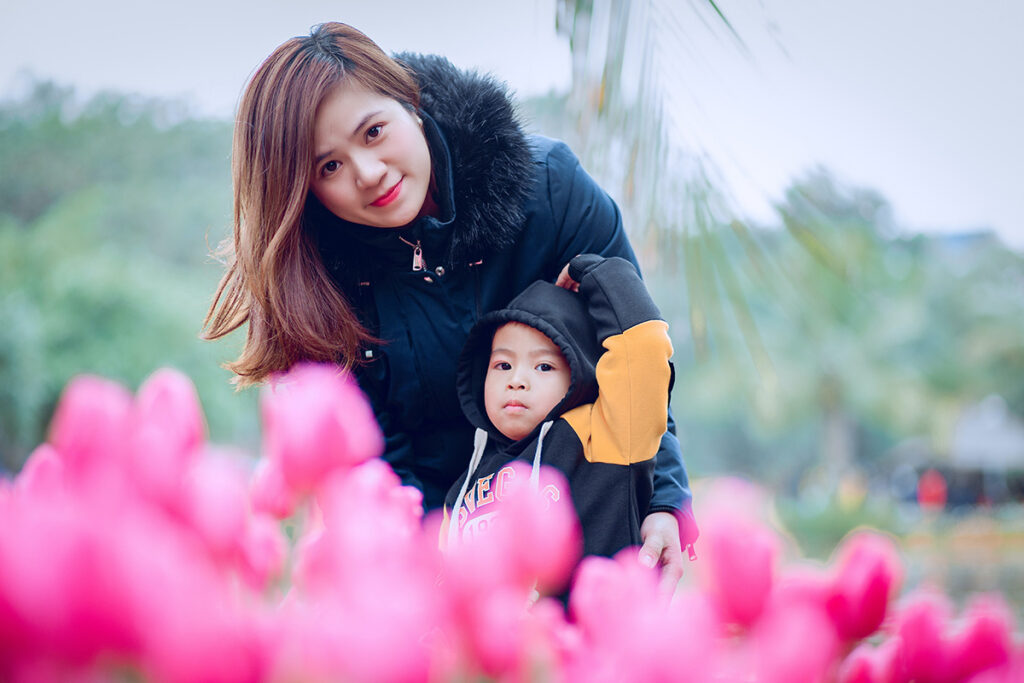 A mother and child enjoy a garden of tulips.