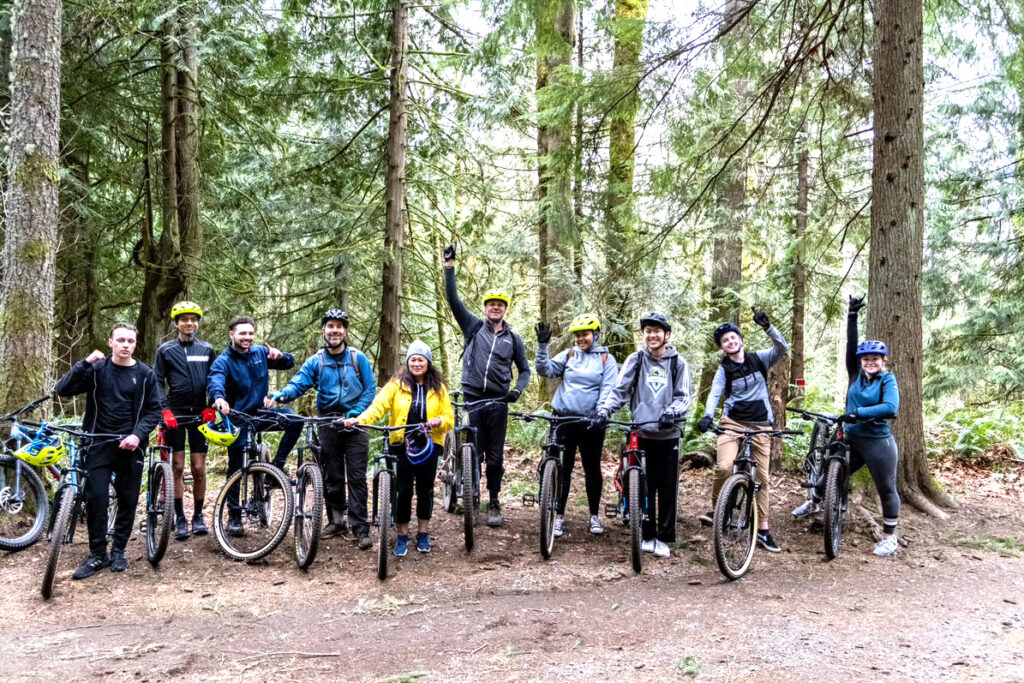 A group of ten students standing on a forest road with their bikes.