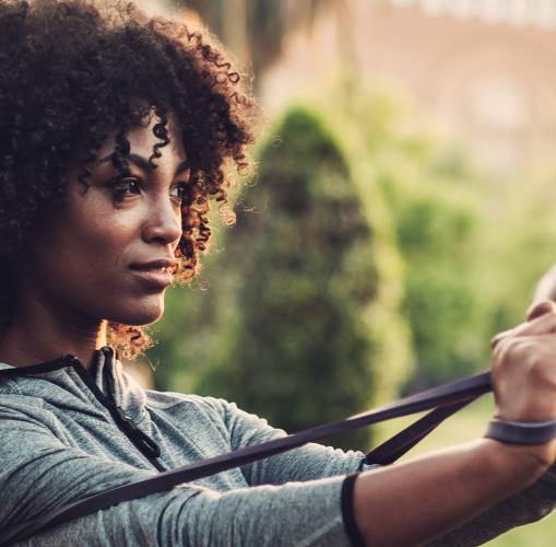 Woman training outdoors with a fitness band.