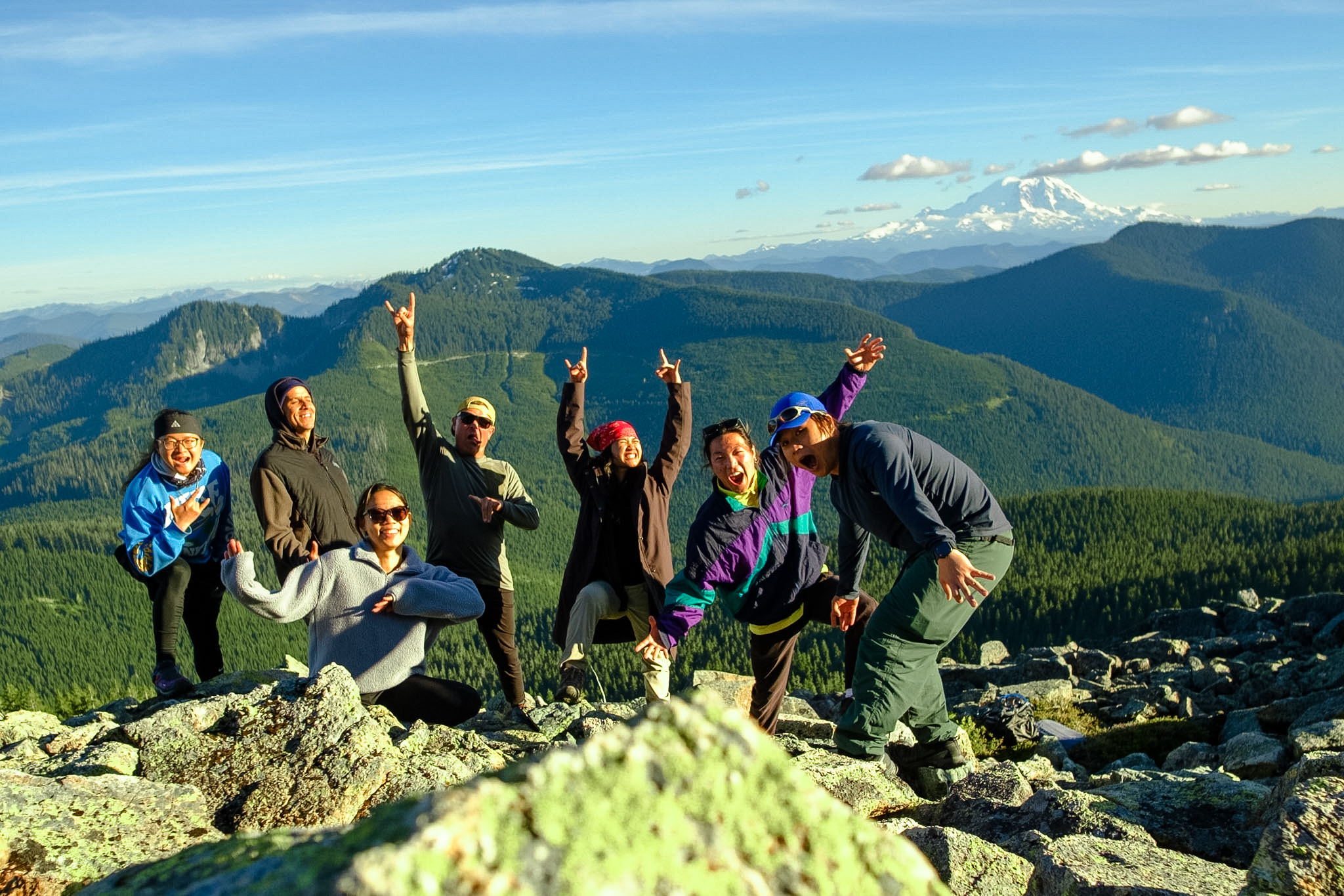 Students on a talus outcrop above Mirror Lake share the evening sun with Mt Rainier and impossible clouds far in the distance.