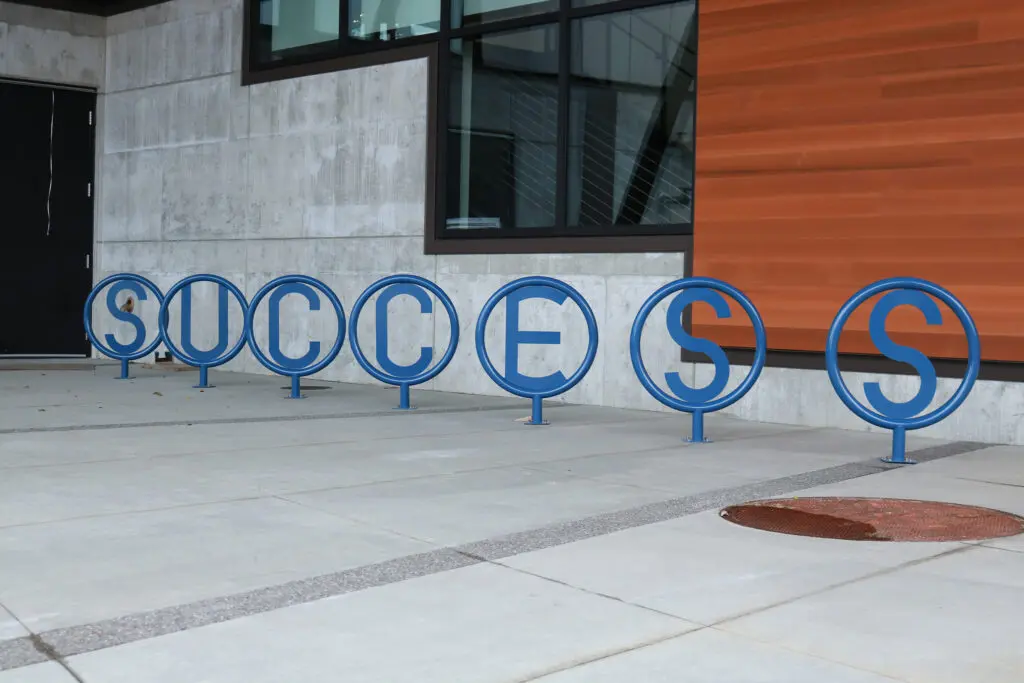 The bike rack by BC's U Building spells out the word "success."