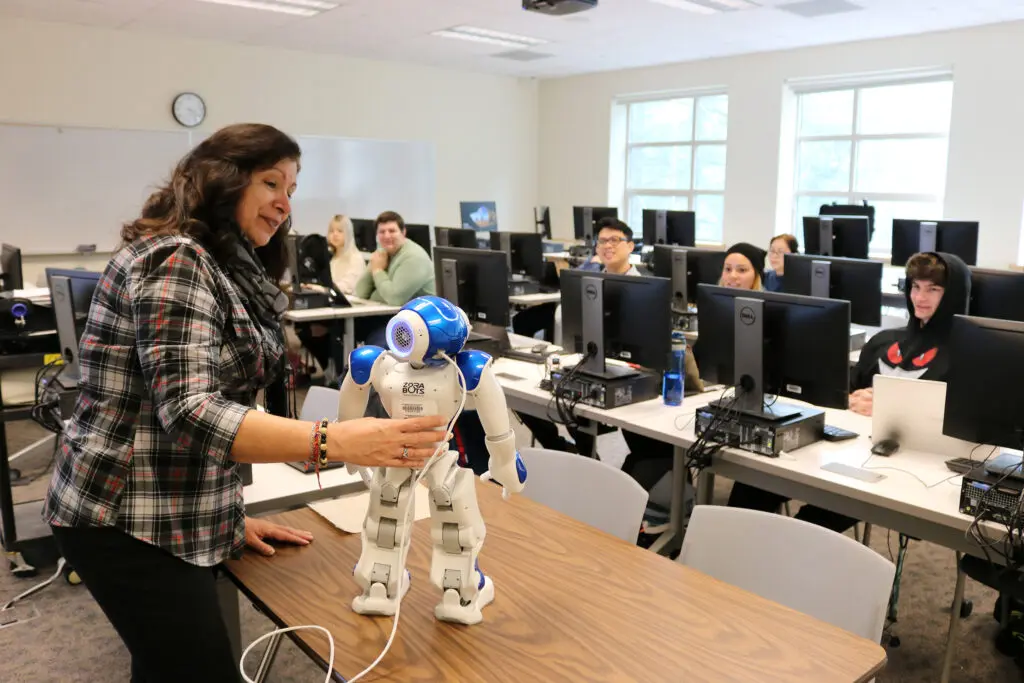 A professor models a robot for the class.