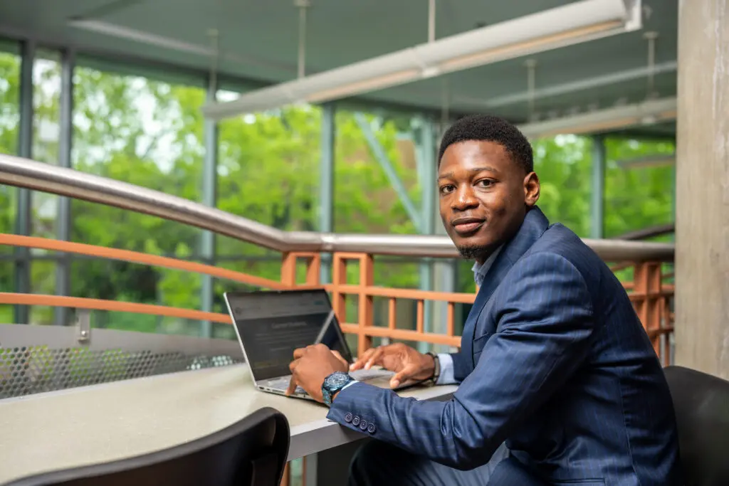 A student works at a laptop.