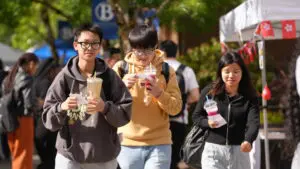 Asian students enjoying Boba tea in the sunshine at the International Night Market