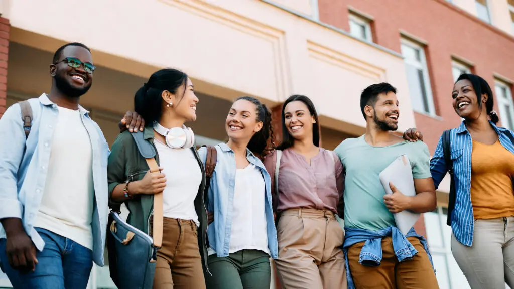 Low angle view of multiracial group of happy college students having fun after the lecture at campus.