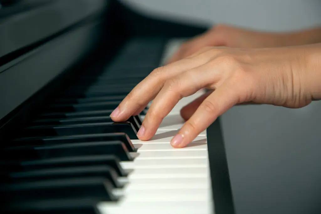 close up of hands playing the piano