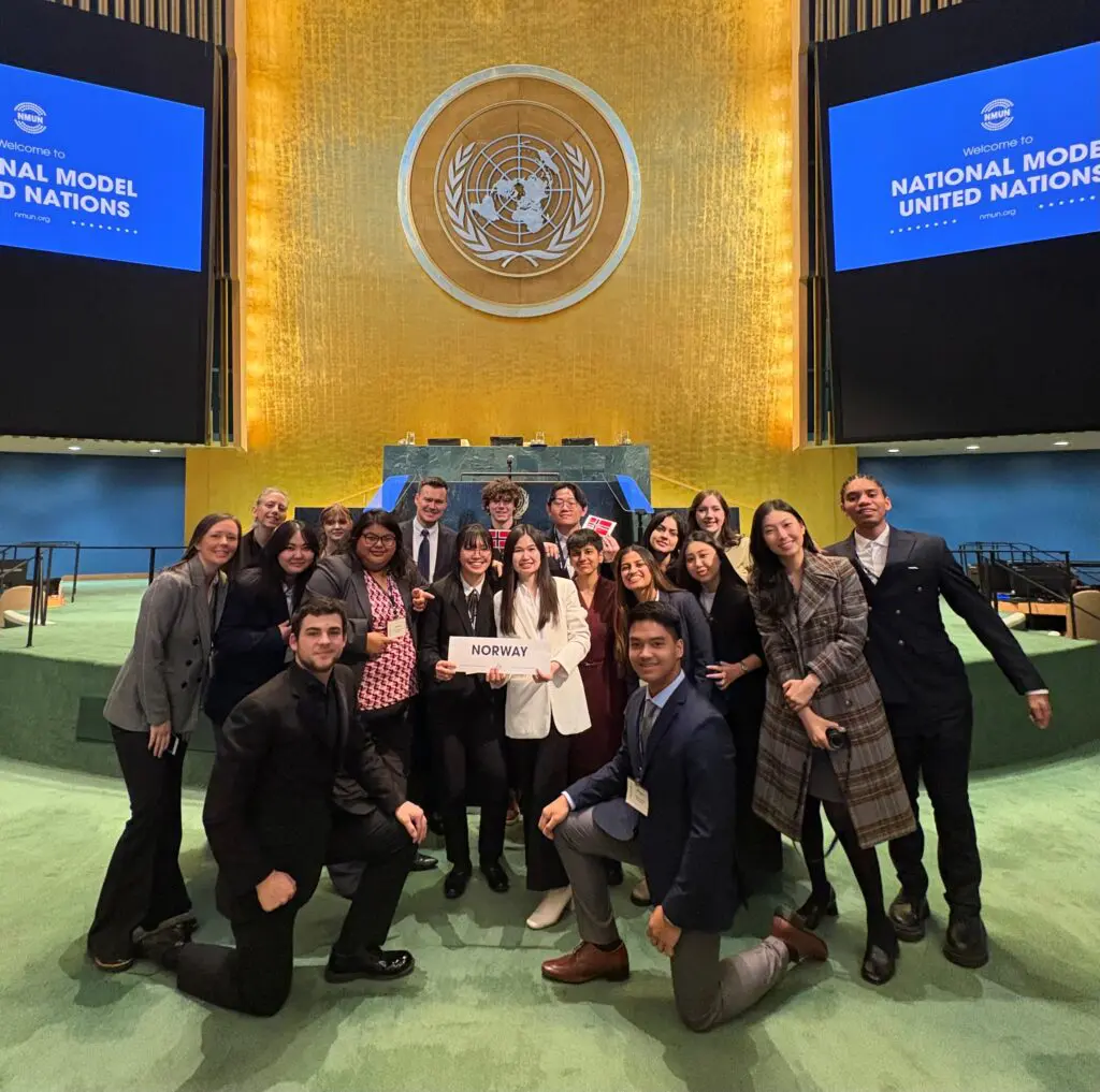 Group photo of BC students and faculty on the Model UN stage in New York representing Norway country