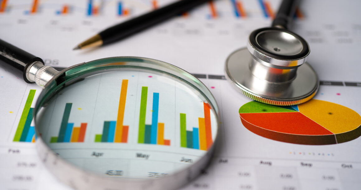 A stethoscope rests on a report with a bar chart