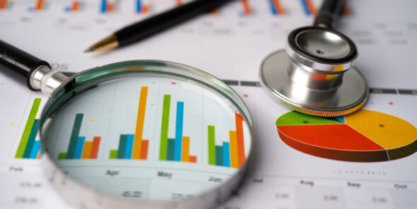 A stethoscope rests on a report with a bar chart