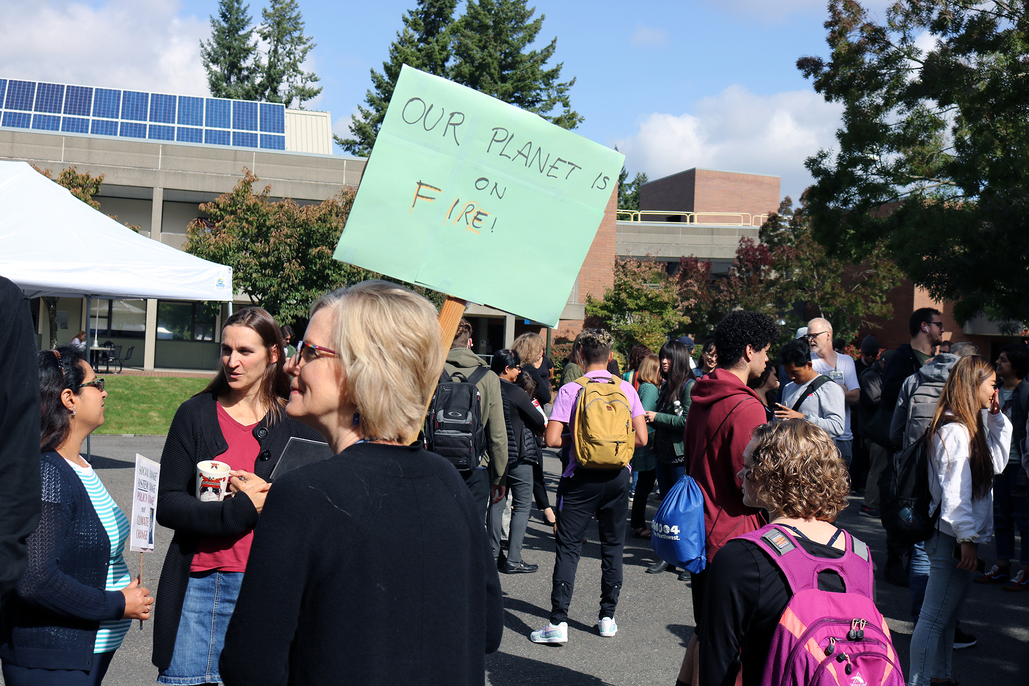 Climate striker holding a sign that says Our Planet is on Fire