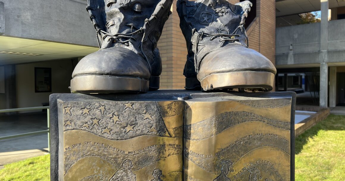 Two boots in bronze sit atop a bronze book