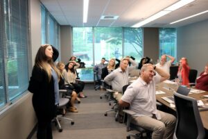 Students lead a wellness exercise where everyone puts a hand on their head