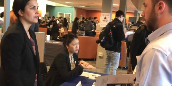 Photo of employer talking to student at job fair