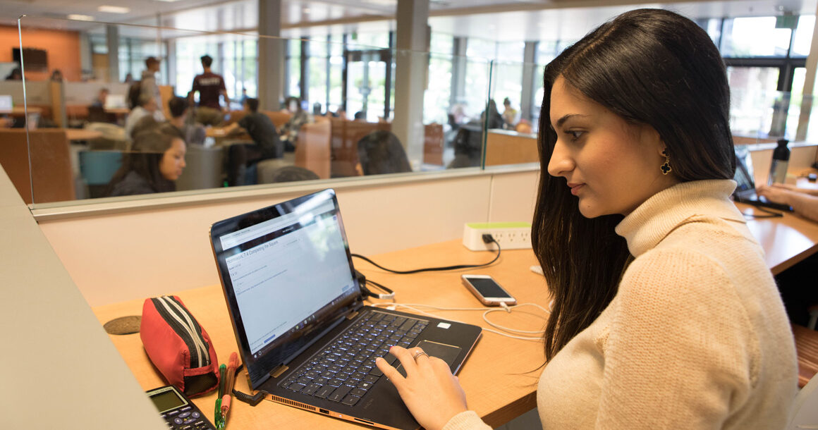 Student working on a laptop in the R Building