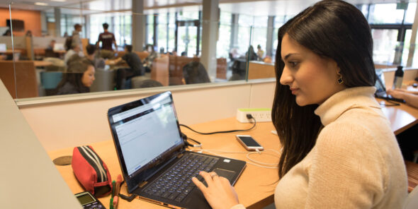 Student working on a laptop in the R Building