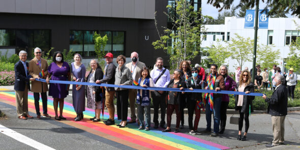 Cutting the ribbon at the rainbow crosswalk dedication