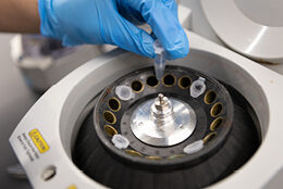 Close-up view of specialized machinery being calibrated by a gloved hand.