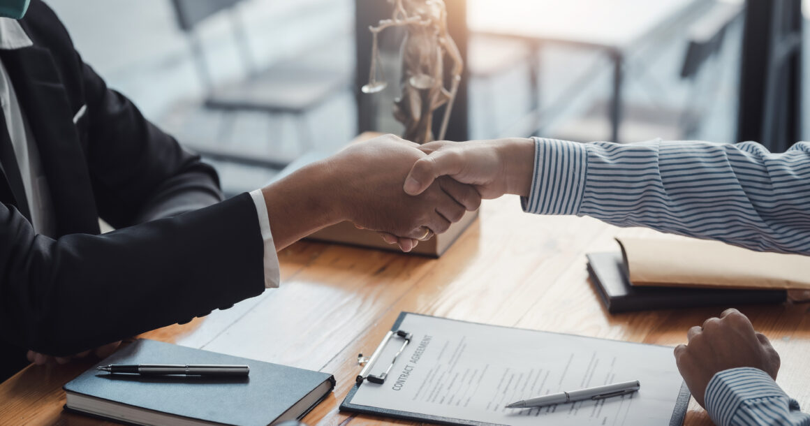 Two people shaking hands after signing partnership contract