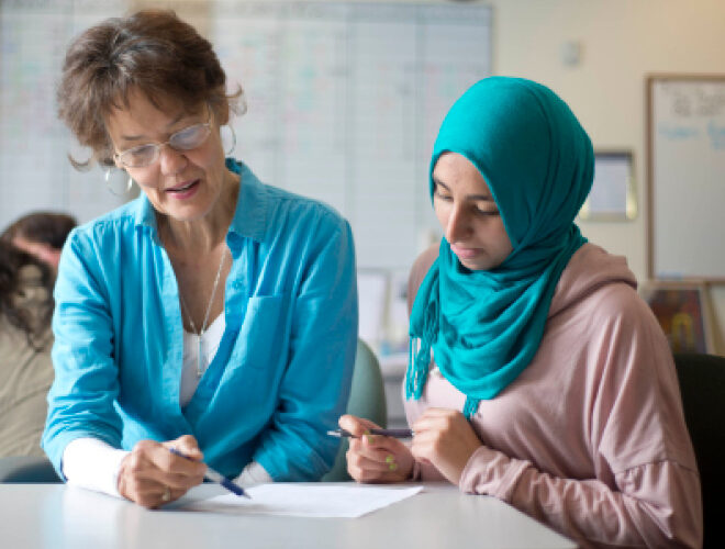 An advisor discusses a worksheet with a student.