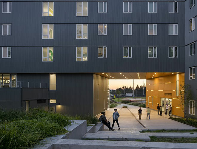 Students in large covered entryway in front of office.