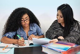 A parent and child work on homework together.