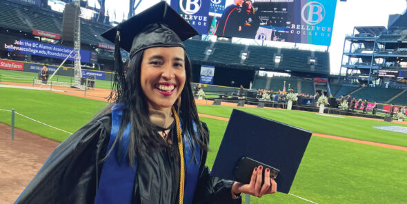 A student celebrating graduation on T-Mobile Field