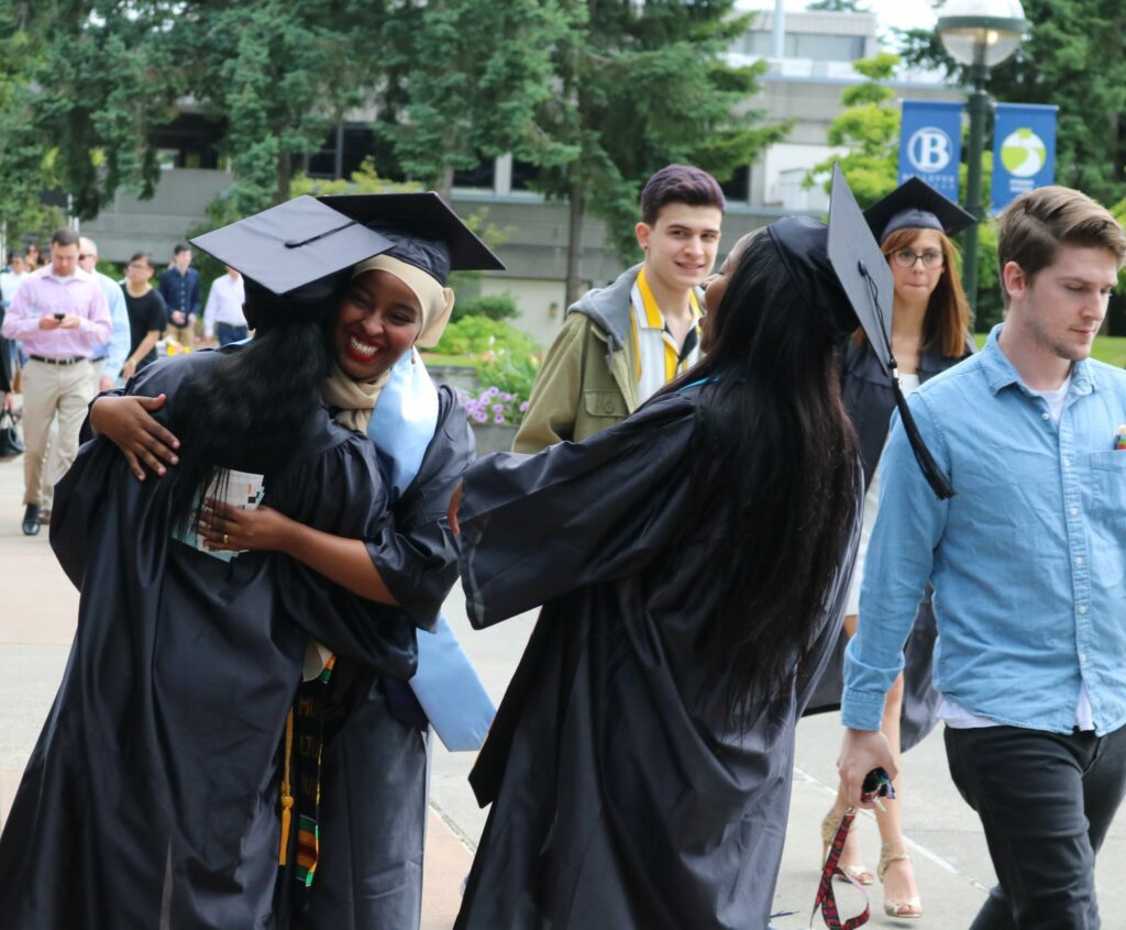 Students laugh and hug prior to the graduation ceremony