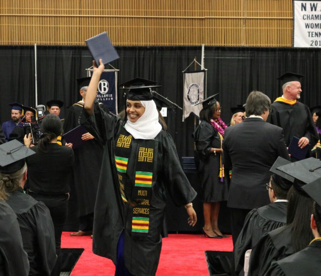 A student waves her diploma during the graduation ceremony