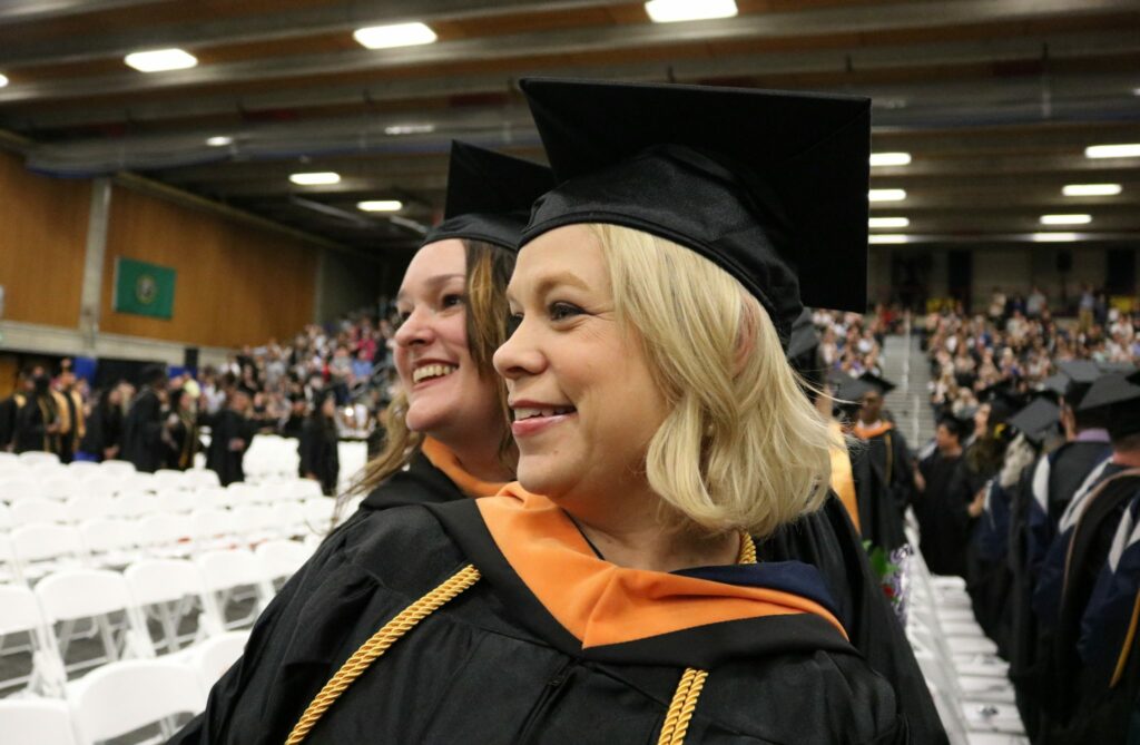 Two women smile during the graduation ceremony