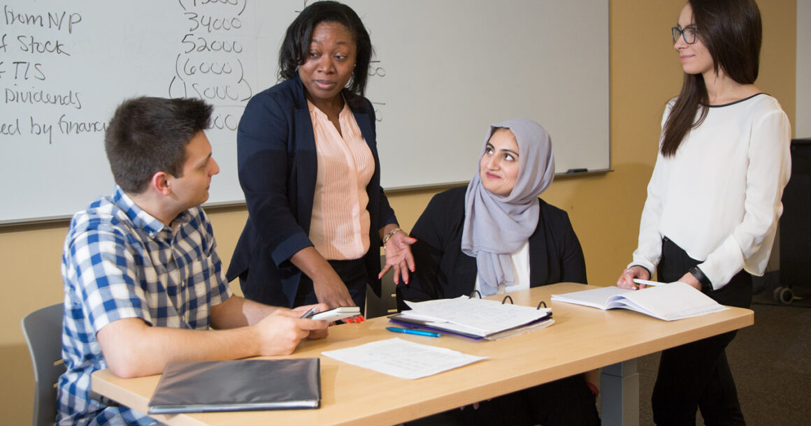 A professor working with students in a classroom