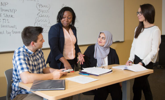 A professor working with students in a classroom