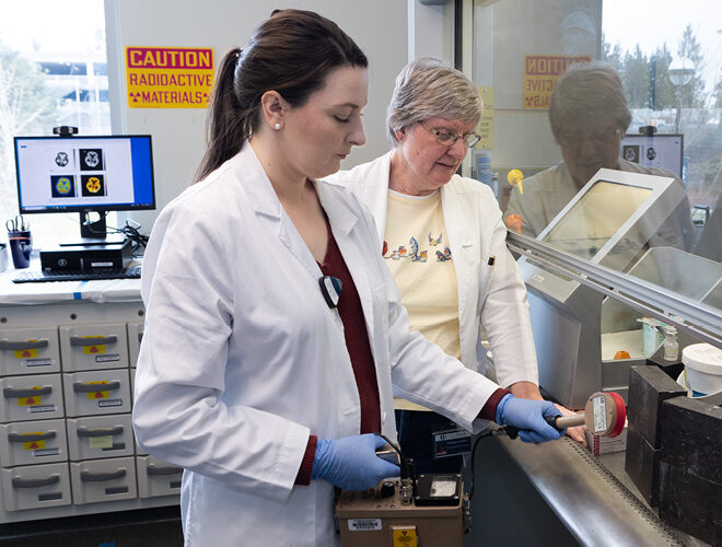 A student and professor work in a science lab.