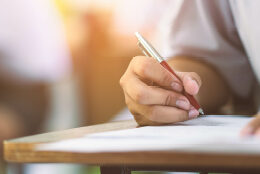 A student fills out an exam by hand.