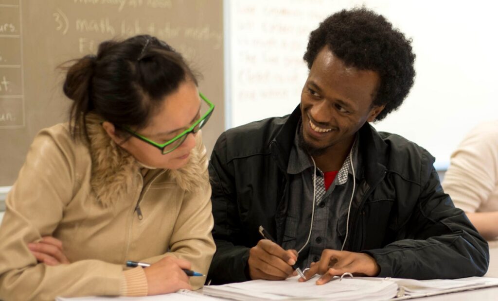 Two people reviewing a text