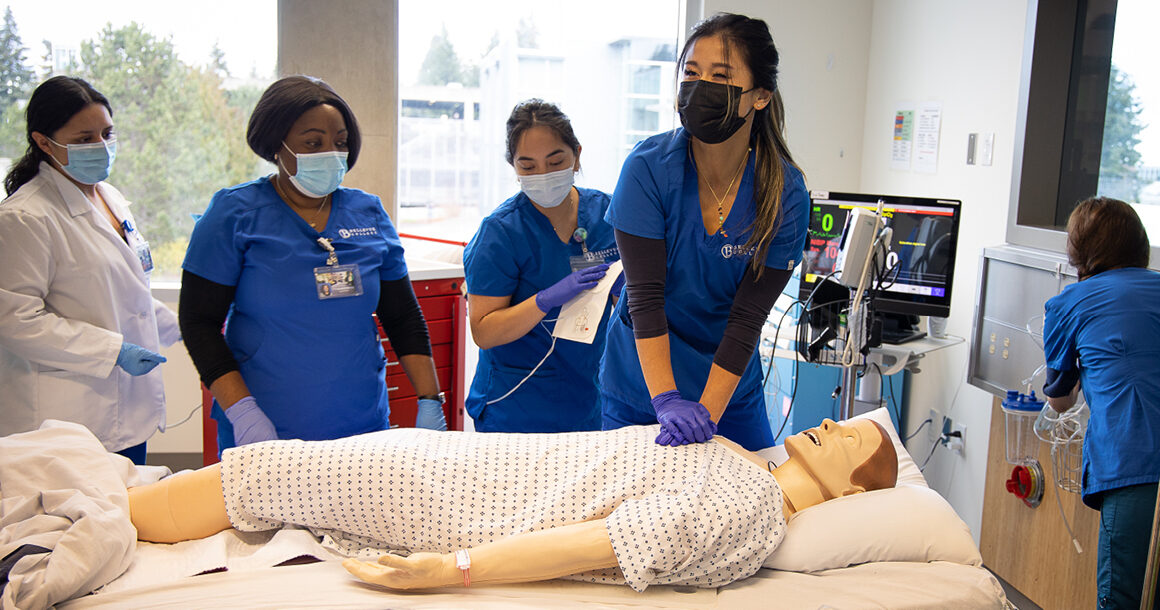 Nursing students practice hospital techniques on a dummy.