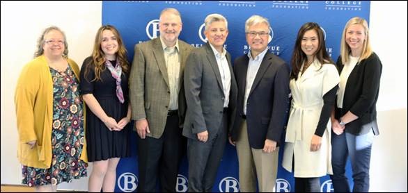 Employees from Bellevue College and Amazon stand together smiling.