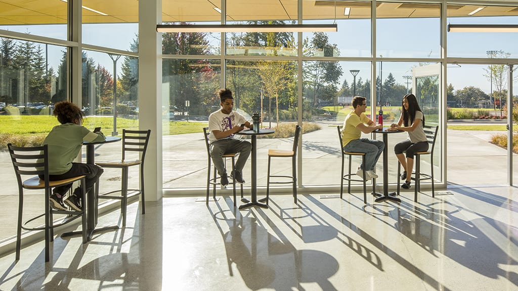 Students sitting in windows of the cafe looking out on patio.