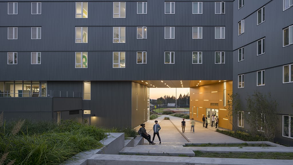 Students in large covered entryway in front of office.