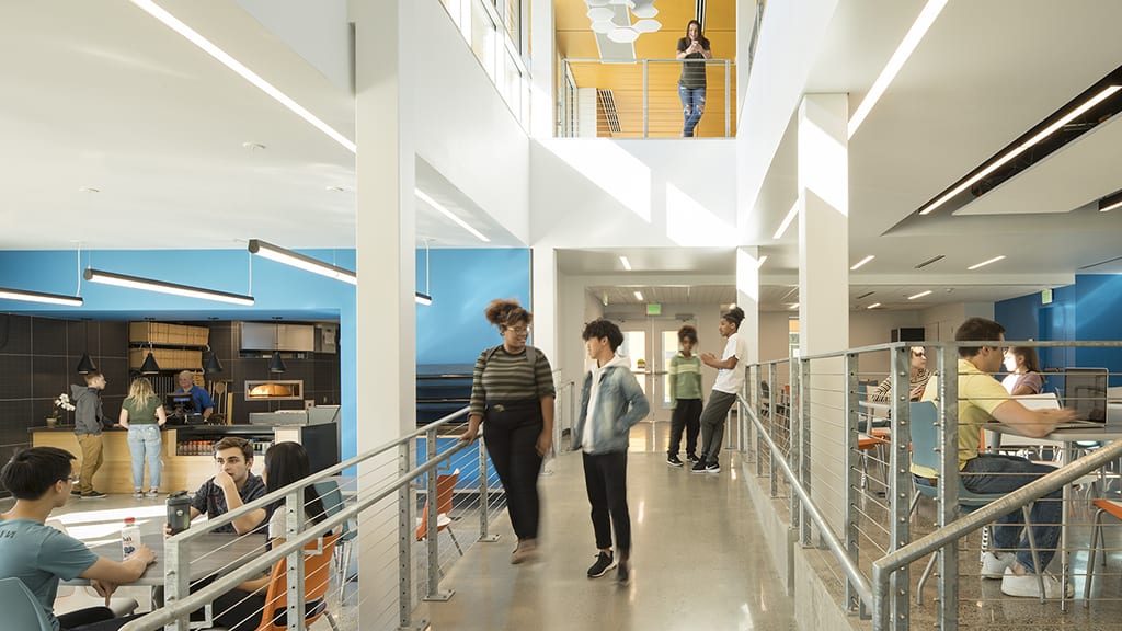 Students in dining area with second floor overlook.