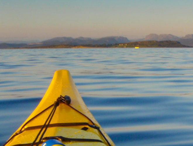 Bow of a yellow kayak looking out over open water