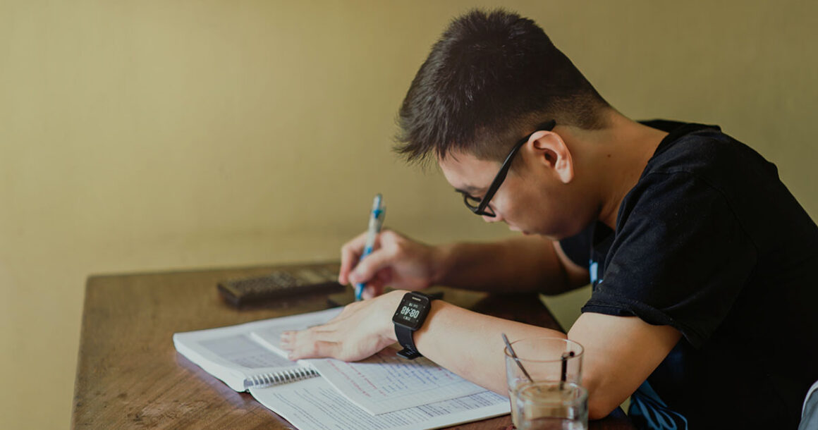 Man in Black Shirt Sitting and Writing