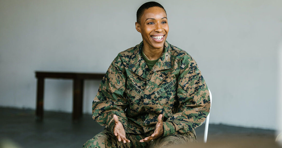 A military service member smiles in conversation.