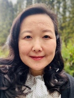 A person with brown long hair smiling at camera.