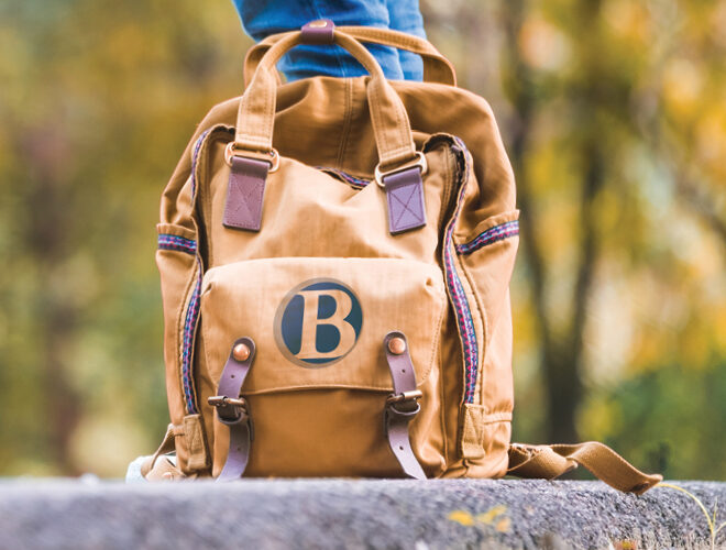 A BC-branded backpack sits at a student's feet.